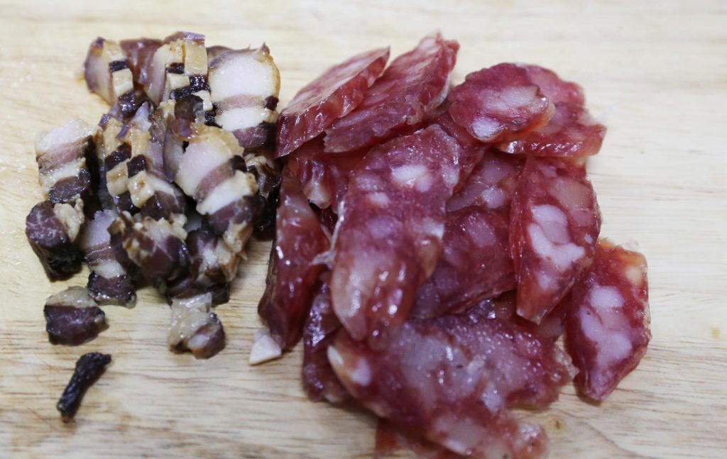 Slice the sausage and cured pork belly into thin pieces.