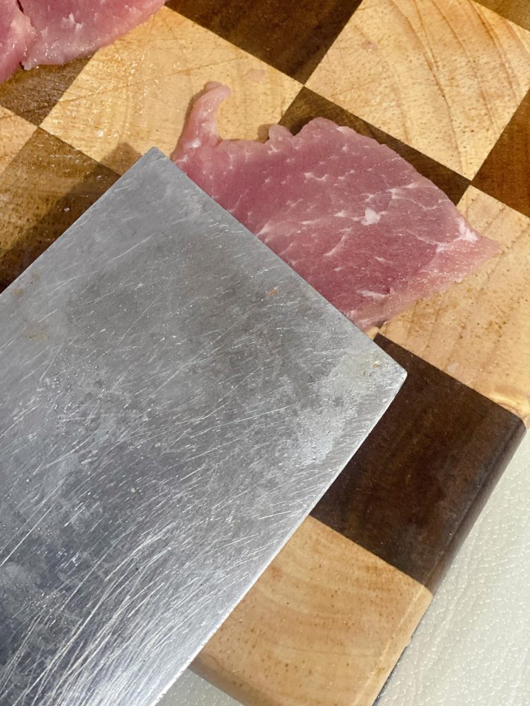 Place the pork slices on a cutting board. Using the back of your knife or a meat mallet, gently pound each piece.