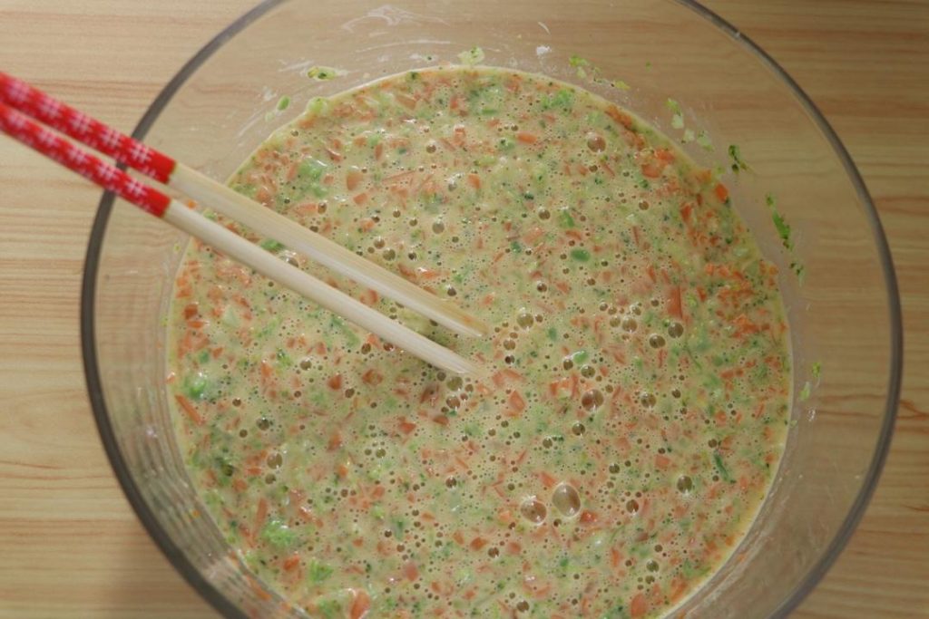 Add the finely chopped broccoli and carrot to the egg batter.