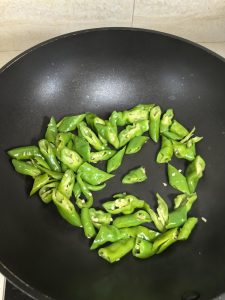 Add the sliced green peppers to the DRY WOK
