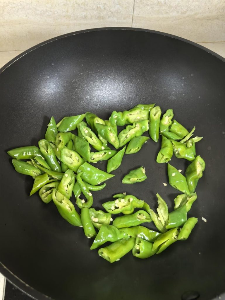 Add the sliced green peppers to the DRY WOK