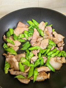 Add the minced garlic to the wok with the pork. Stir-fry for about 15-30 seconds until you can smell it.
