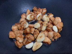 Add the fried garlic cloves back into the pan with the chicken.