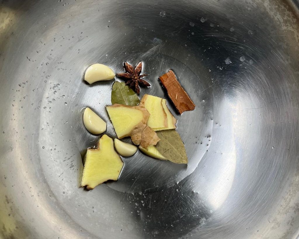 add the aromatics: ginger, garlic, star anise, cinnamon, bay leaves, and optional dried chilies.