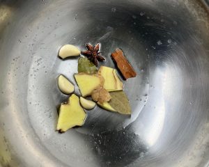add the aromatics: ginger, garlic, star anise, cinnamon, bay leaves, and optional dried chilies.