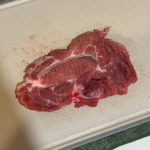 Using the back of your knife, a meat mallet, or even a heavy rolling pin, give the pork a good pounding.