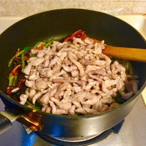 Return the cooked pork shreds to the pan.