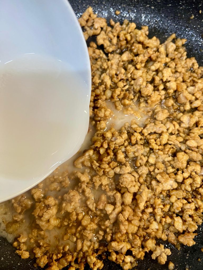 Give your cornstarch slurry a quick stir (the starch settles!) and pour it into the wok.