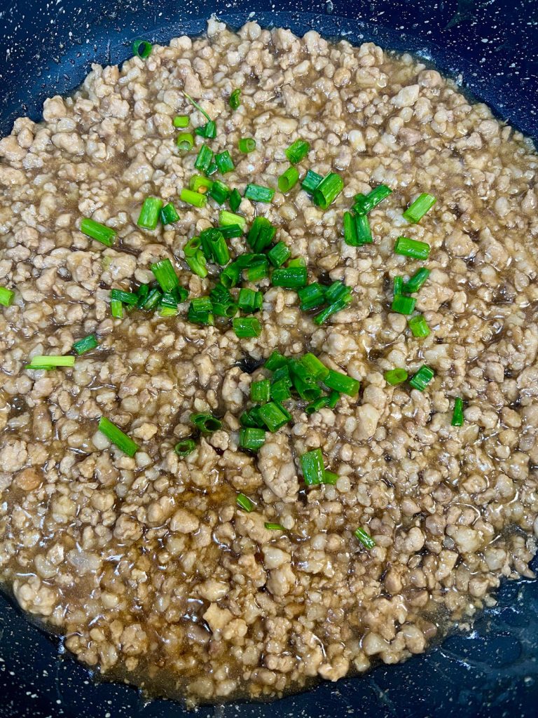 Turn off the heat and stir in most of your chopped green onions, saving a few for garnish.