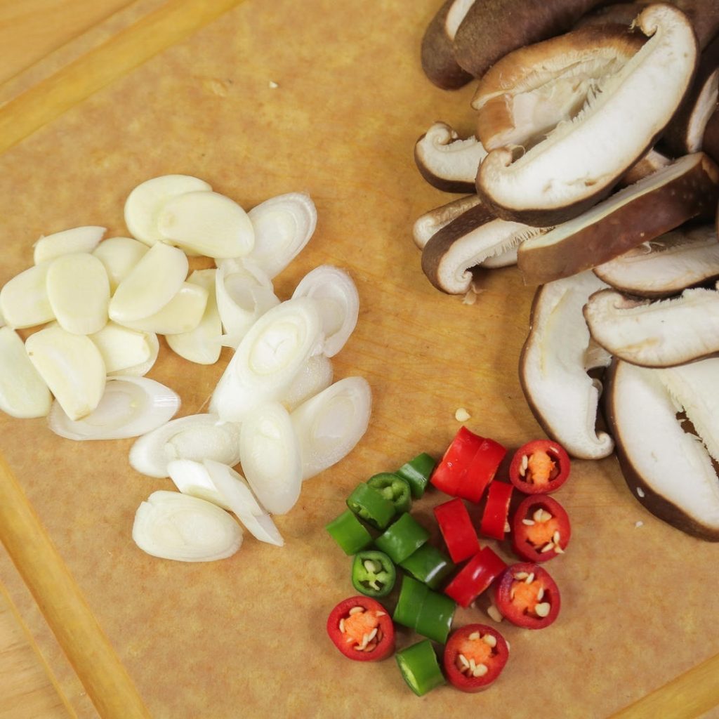 slice the shiitake mushrooms into thick slices (about 0.5cm). Slice the green and red peppers into rings. Chop the scallion and slice the garlic.