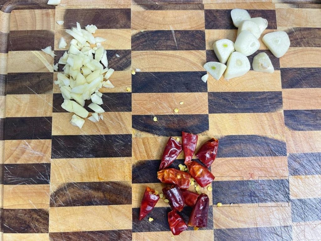Aromatics: Cut the dried chilies into segments. Slice half the garlic cloves; mince the other half finely and set aside.