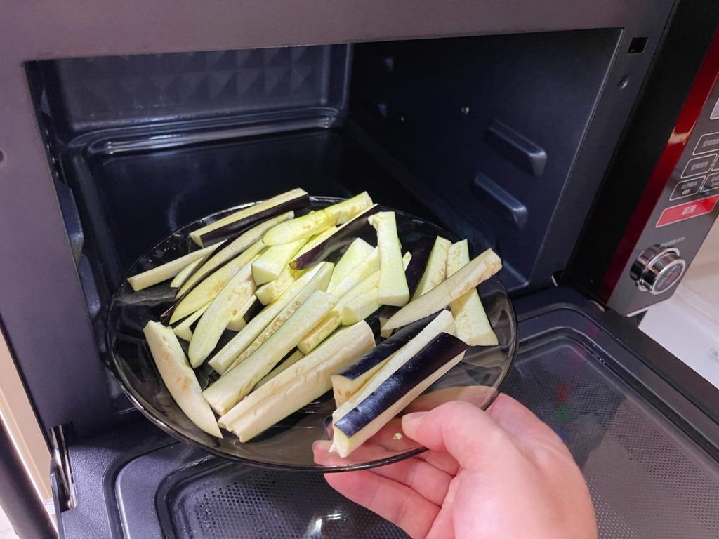 Place the eggplant strips and bean sections in a microwave-safe bowl. Cover loosely and microwave on High for 3 minutes.