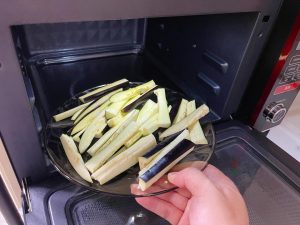 Place the eggplant strips and bean sections in a microwave-safe bowl. Cover loosely and microwave on High for 3 minutes.