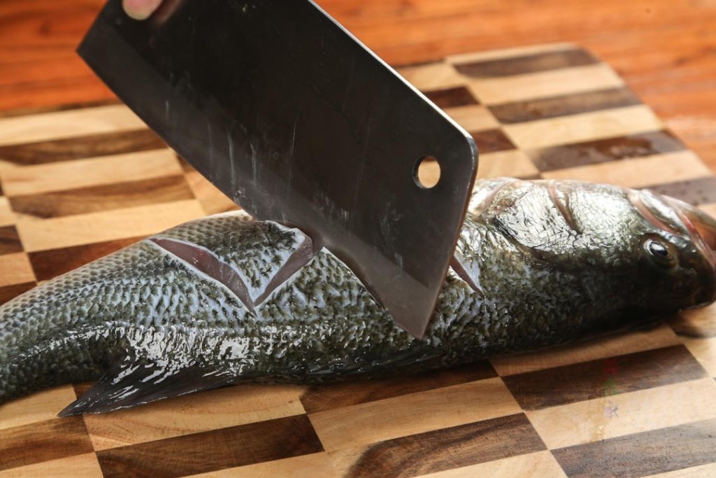 Score the Fish Pat the fish completely dry with paper towels.Using a sharp knife, score the fish on both sides. Instead of simple slashes, try a "Z" shape or "Zig-Zag" pattern.