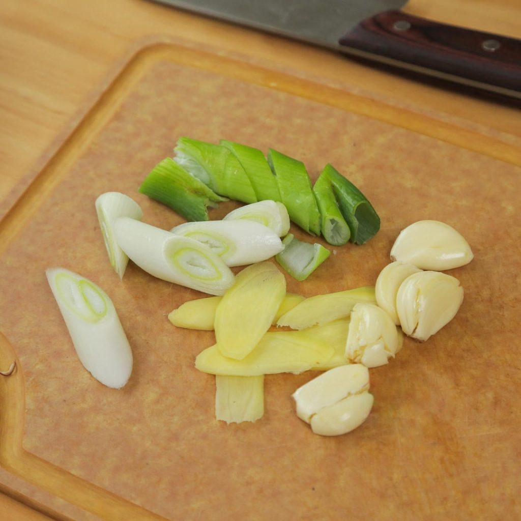 While the ribs blanch, smash the garlic cloves (no need to slice), slice the ginger, and cut the scallion into 2-inch segments.