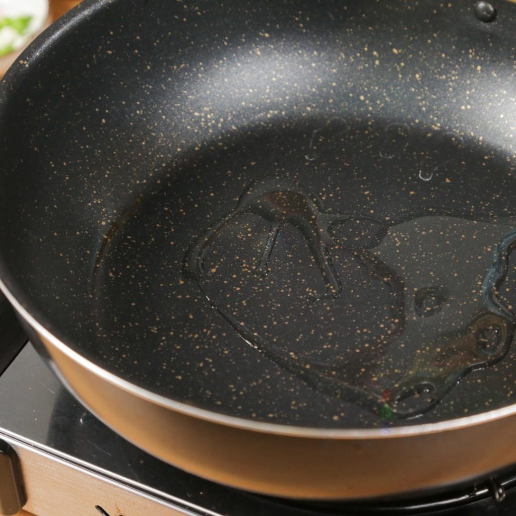 Heat 3 tbsp of neutral oil in a 12-inch wok or skillet over medium-high heat.