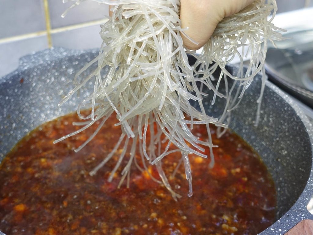 Braise the Noodles: Add the soaked vermicelli to the wok.