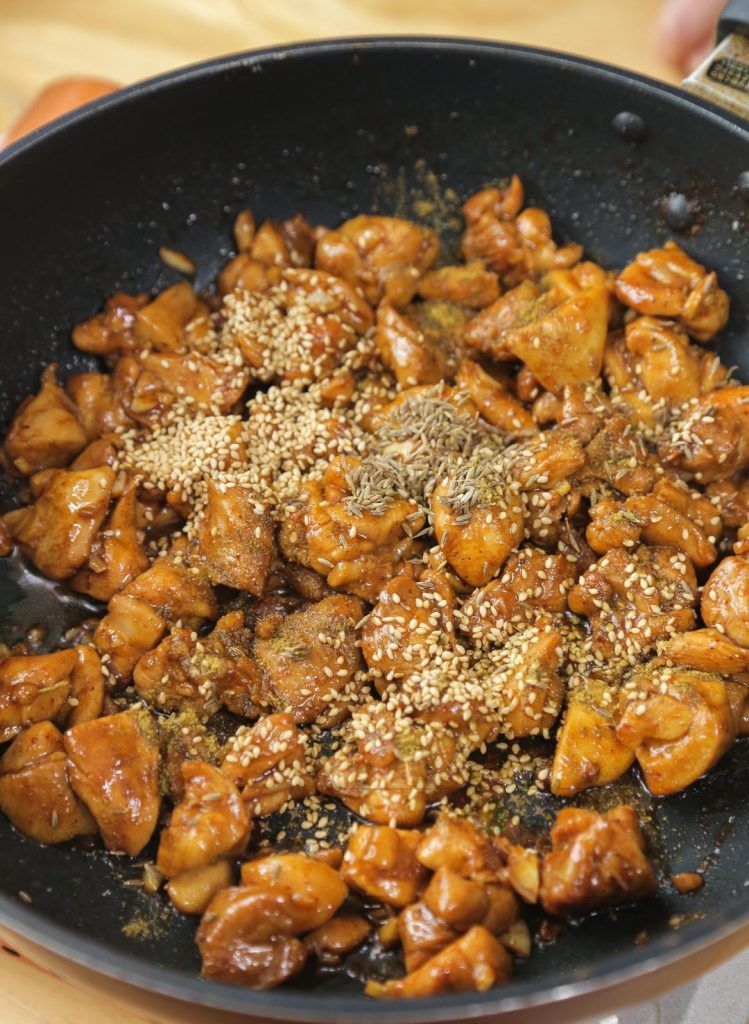 Season Sprinkle the cumin powder, cumin seeds, and white sesame seeds (and extra chili powder if you like it spicy) over the chicken.