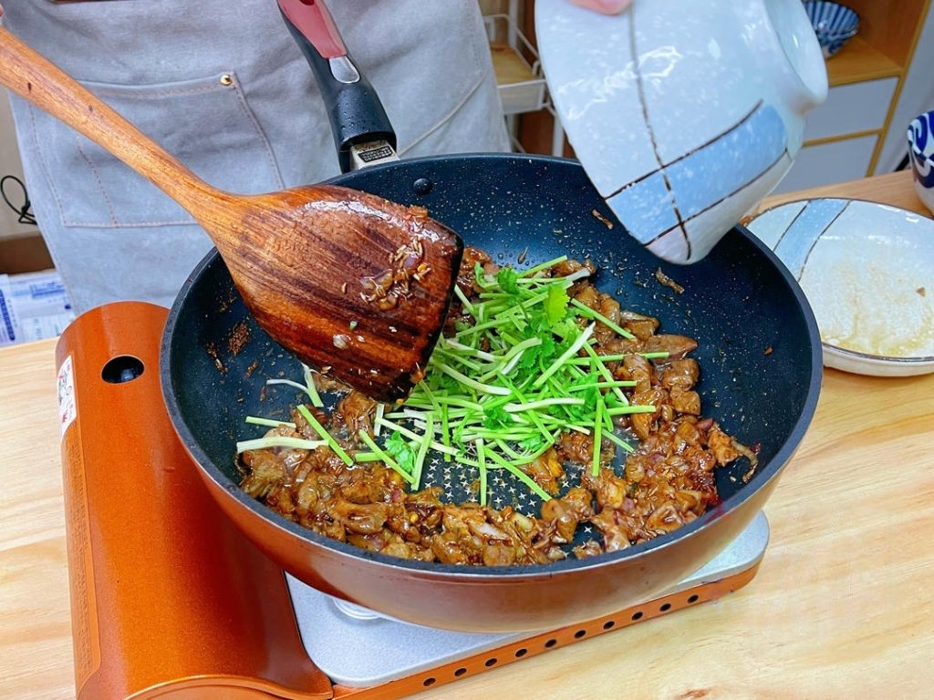 Toss the cooked lamb back into the pan and mix everything so the meat is coated in the bubbling sauce.