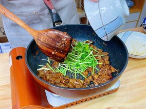 Toss the cooked lamb back into the pan and mix everything so the meat is coated in the bubbling sauce.