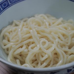 Drain the noodles and transfer them to serving bowls.