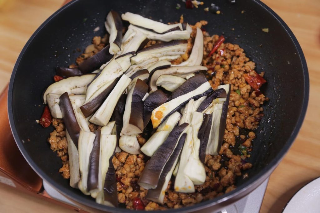Add the microwaved eggplant strips to the pan.
