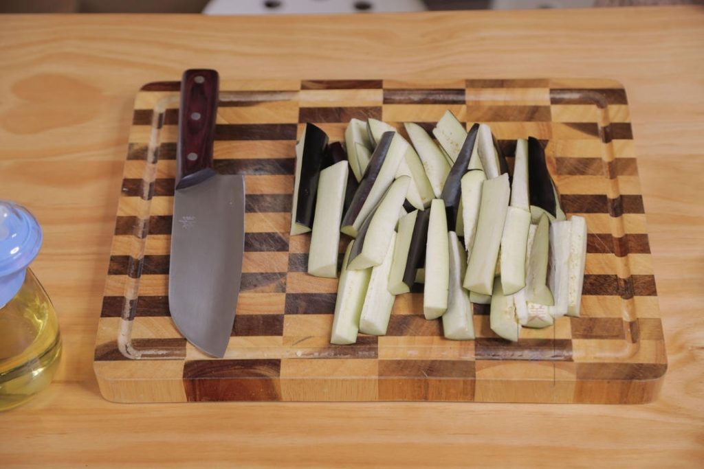 Wash the eggplants. You do not need to peel them. Cut them into strips about the length and thickness of your index finger.