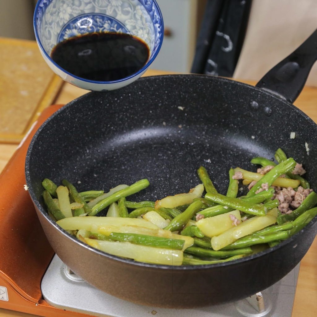 Add the cooked potatoes and green beans back into the pan with the pork.