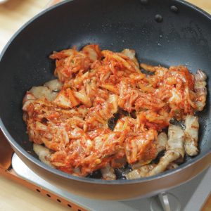 Pour the chopped kimchi (and its juices) directly into the pan with the pork and the rendered fat. Turn the heat up to medium-high.
