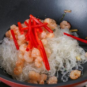 Return the cooked shrimp to the pan. Add the bell pepper strips.