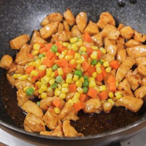 Cook the Vegetables Add the mixed vegetable cubes to the pan with the chicken. Stir-fry for about 1 minute.