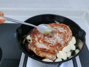 add the butter, rosemary, and garlic cloves (if using) to the pan.