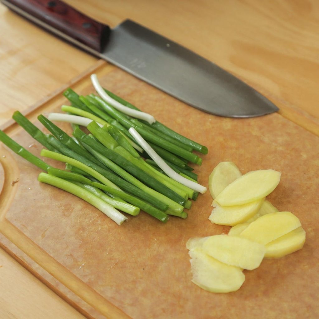 Slice the ginger into thick coins and cut the scallions into 2-inch segments.