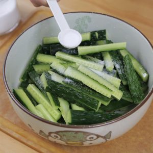 Place your cucumber strips in a large bowl. Add about 2 tablespoons of salt (or 1 "porcelain spoon" as we say in the family kitchen). Toss well to coat.