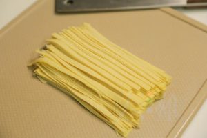 Stack the tofu sheets and slice them into thin strips, about 1/8 inch wide (similar to fettuccine).
