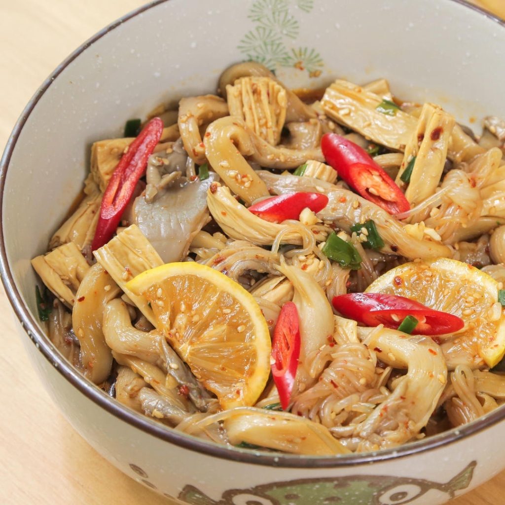 Pour the dressing over the drained mushrooms, konjac, and yuba. Add the lemon slices and fresh chili peppers. Toss everything together until well coated.