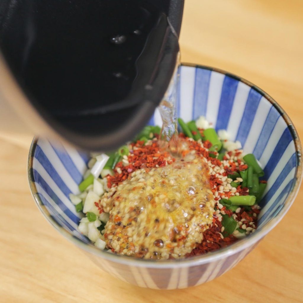 Carefully pour the hot oil directly over the garlic and chili pile.