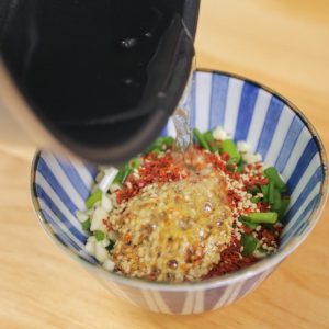 Carefully pour the hot oil directly over the garlic and chili pile.