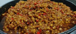 Pour the soaked soybeans (and all the soy sauce liquid) into the wok.