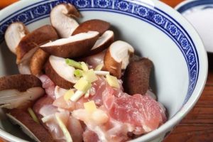 Combine Place the chicken chunks into a mixing bowl. Add the sliced mushrooms, ginger, and scallions.