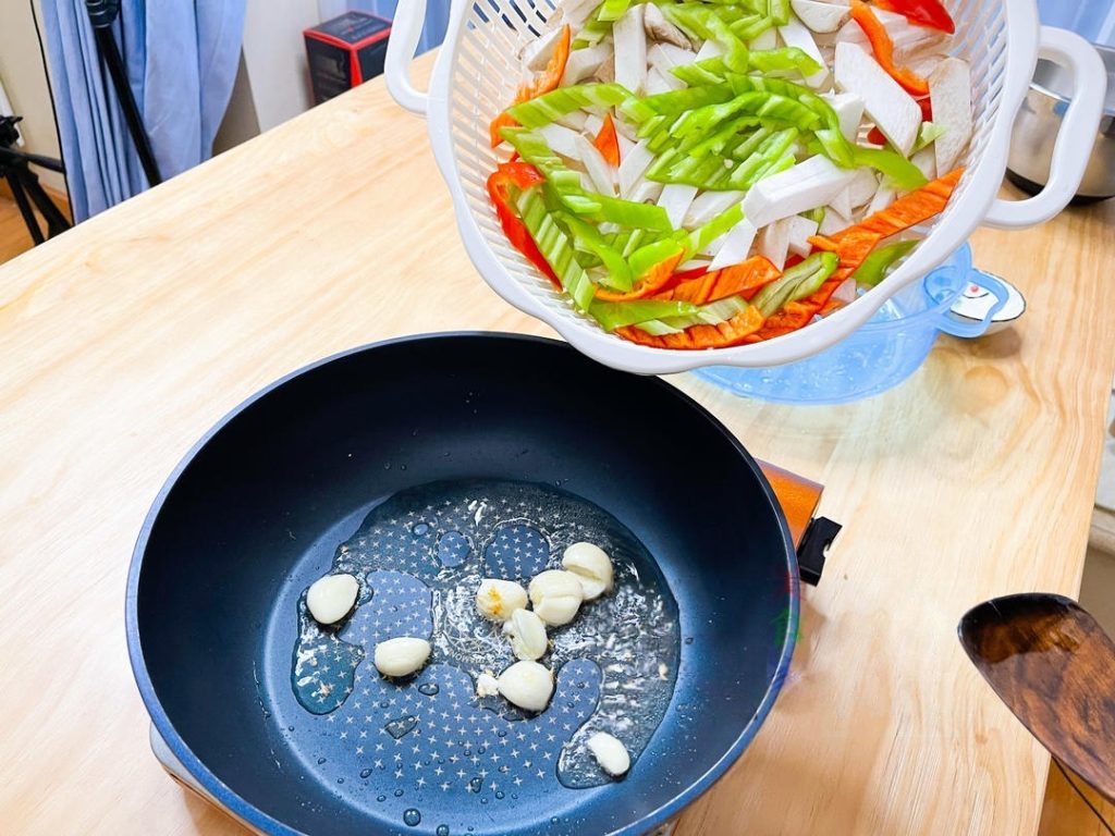 Add the sliced mushrooms and peppers. Stir-fry continuously. Do not rush this step.