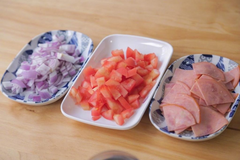 Slice the onion into small dice (about the size of your pinky nail). Cut the ham into bite-sized squares. Dice the tomato last so it doesn't leak juice all over your cutting board.