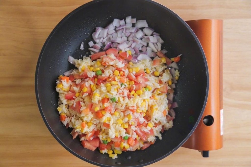 Add the rice mixture to the pan. Stir-fry constantly over medium heat. You want to cook until the egg coating on the rice solidifies and the grains start to separate.