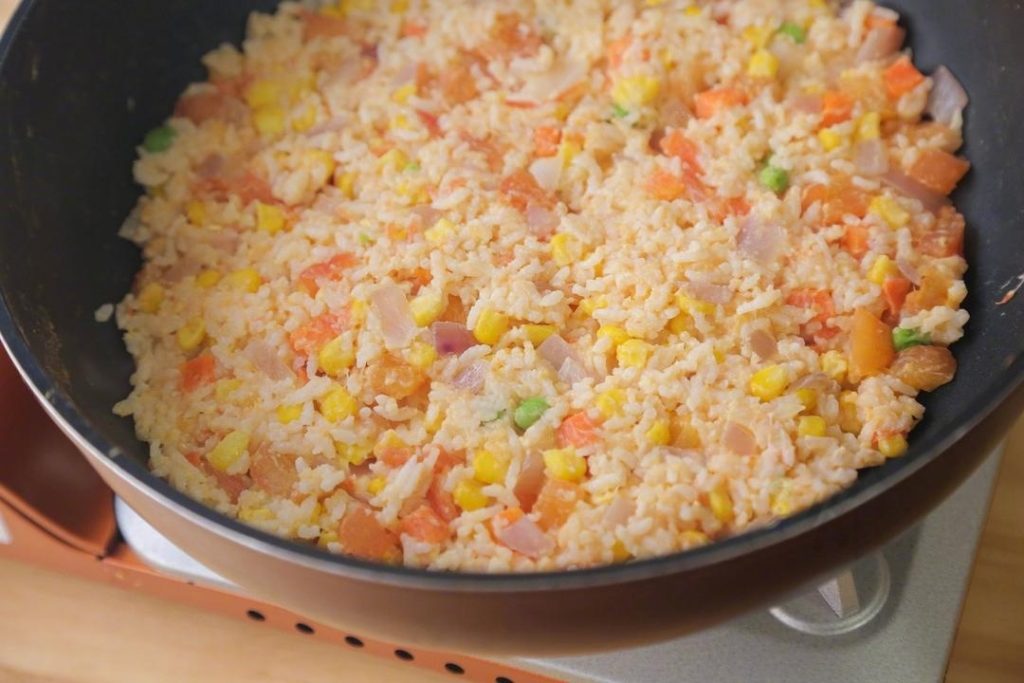 Add the rice mixture to the pan. Stir-fry constantly over medium heat. You want to cook until the egg coating on the rice solidifies and the grains start to separate.