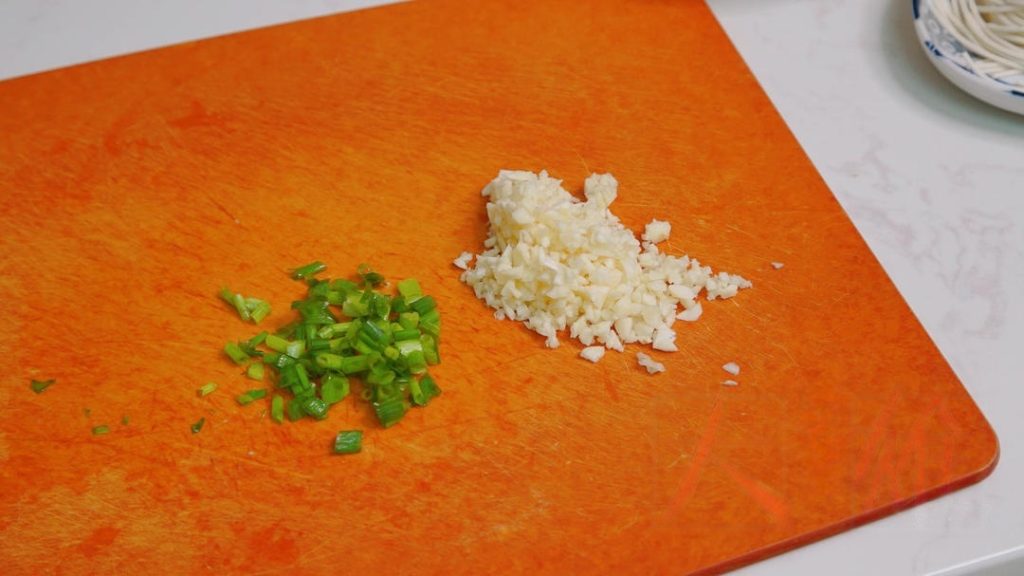 The smaller they are, the faster they will break down into a sauce. Mince your garlic and separate the scallion greens.
