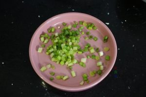 First, wash your scallions and chop them into small rings. Crack the eggs into a small bowl, add the chopped scallions and a pinch of salt, and whisk well until combined.