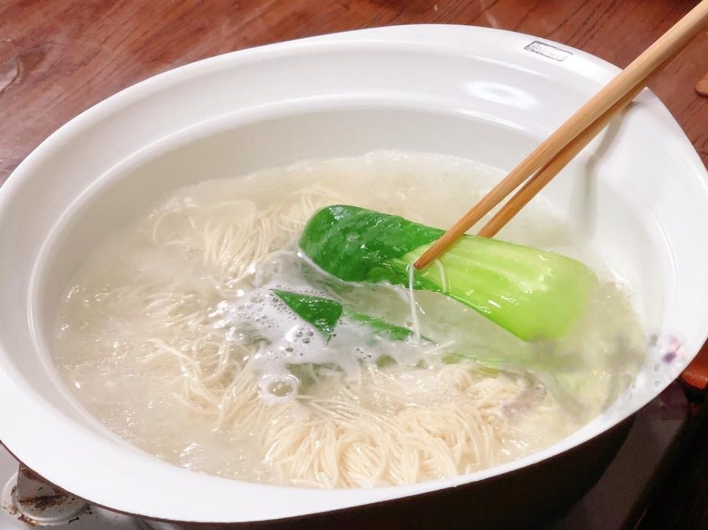 When the noodles are almost done (usually 2-3 minutes for thin noodles), toss in a few leaves of bok choy or choy sum.