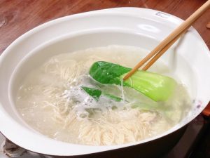When the noodles are almost done (usually 2-3 minutes for thin noodles), toss in a few leaves of bok choy or choy sum.
