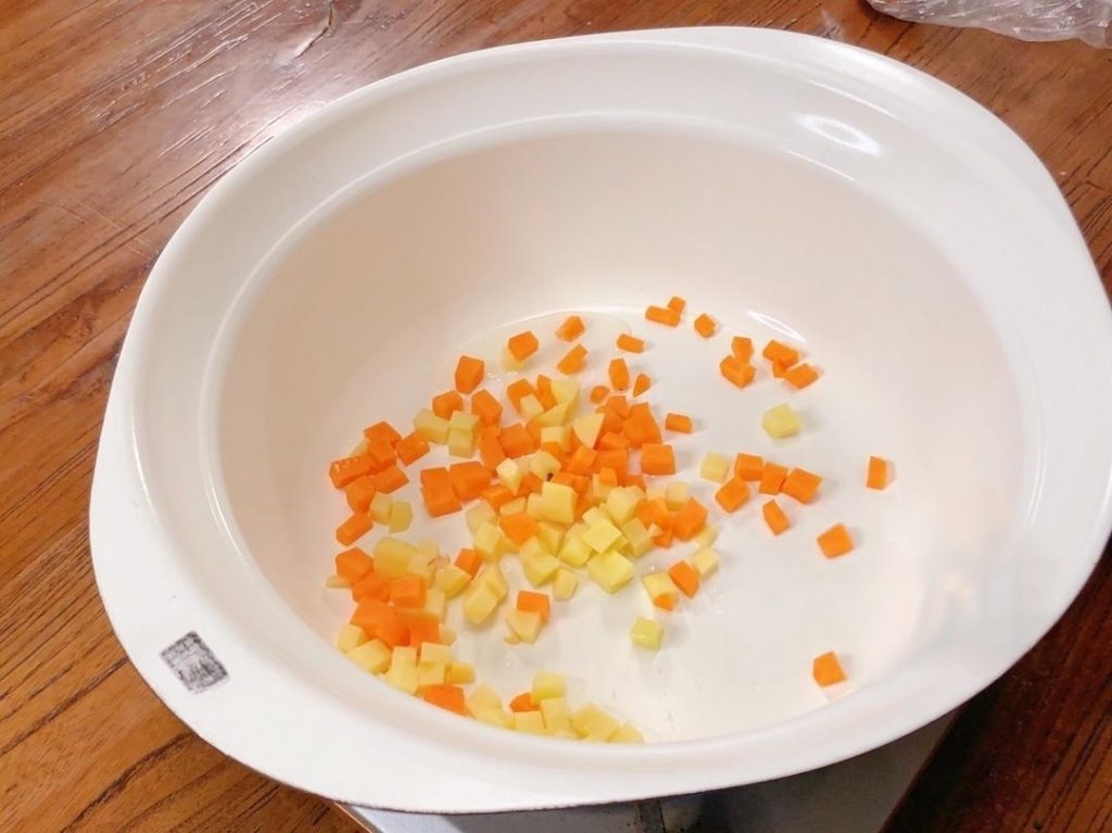 Heat 1 tablespoon of oil in a pan over medium-high heat. Stir-fry the potatoes and carrots until they change color.