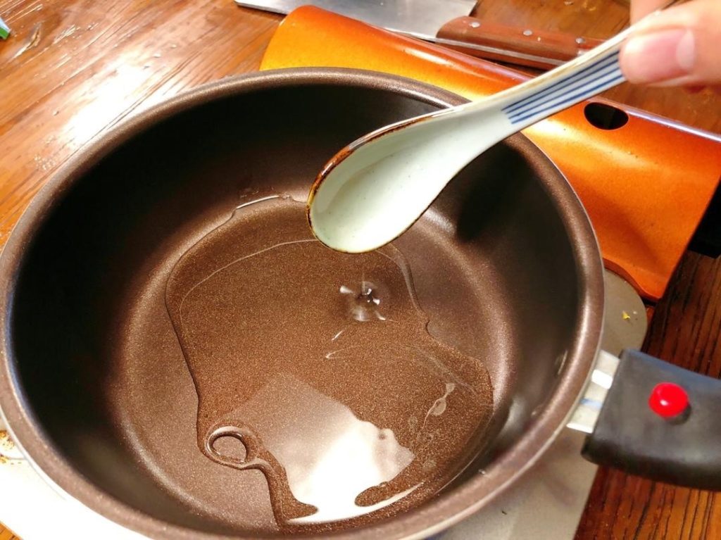 Heat 2 tablespoons of cooking oil in a ladle or small pan until it starts to smoke slightly.